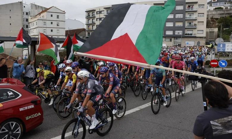 Los ciclista pasan ante las protestas propalestina durante la etapa 16 de la Vuelta Ciclista a España. EFE/ Lavandeira Jr